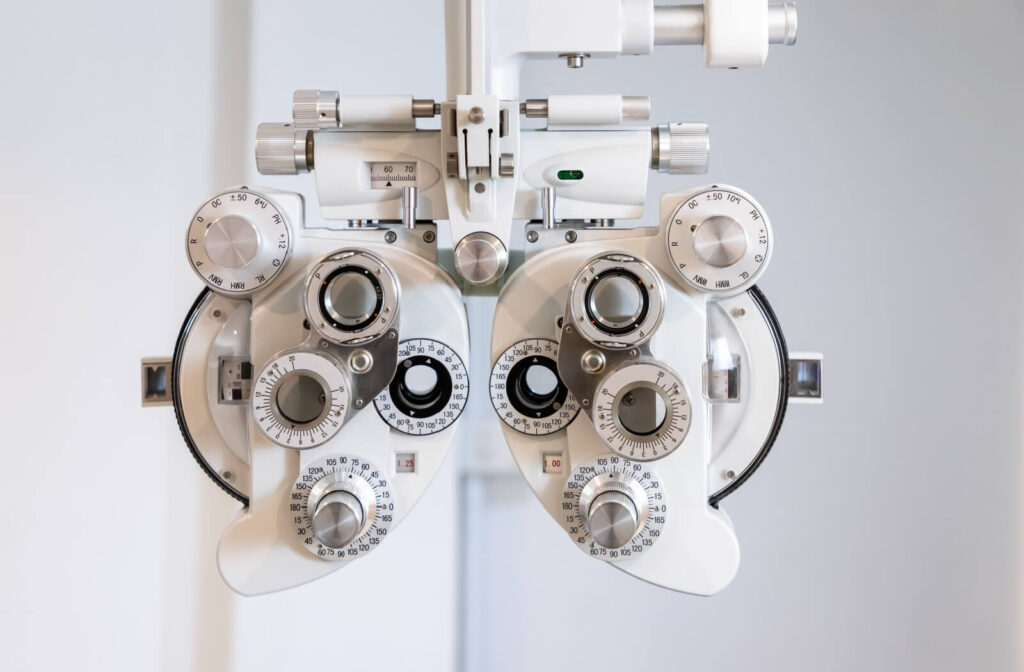 A close-up of a white phoropter used by optometrists to measure refractive errors and determine a patient's eyeglass prescription during an eye exam.